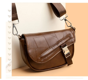 Detail of brown faux leather crossbody bag with geometric patchwork and metal buckle