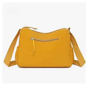 Detail view of the yellow crossbody bag back side showing zipper pocket and wide strap