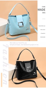 Detail of crocodile pattern bucket bag with square metal buckle and adjustable strap