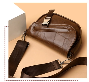 Close-up of brown saddle bag showing lychee grain leather and silver metal buckle detail