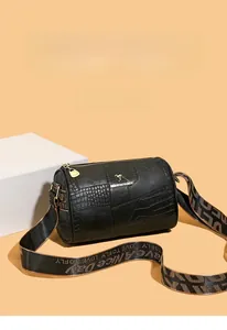 Detail of a mini pillow bag with mixed leather textures and decorative golden logo