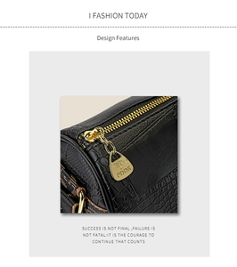 Detailed view of black crocodile pattern leather texture with gold zipper and logo
