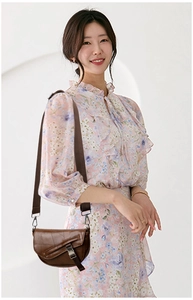 Detail shot of textured dark brown saddle bag with stylish wide adjustable strap