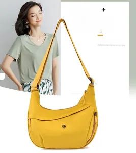 Macro detail of a bright yellow Oxford cloth crescent bag with adjustable wide strap
