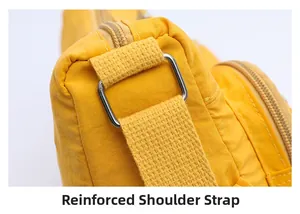 Close-up of reinforced shoulder strap with silver metal buckle on yellow nylon bag