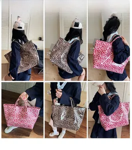 Detail view of large leopard print tote bags in brown and pink on model for commute