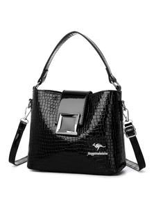Close-up of black crocodile pattern bucket bag with silver buckle and glossy finish