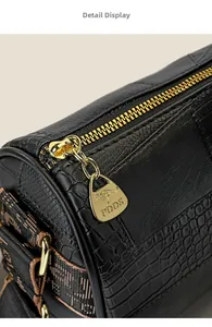 Detail view of gold metal zipper and crocodile texture on black mini Boston bag