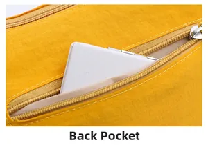 Macro detail of yellow nylon crossbody bag showing back zipper pocket with storage demo