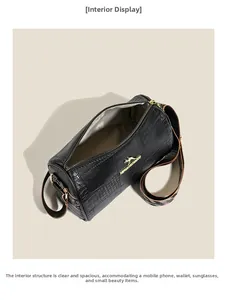 Interior view of crocodile-patterned cylinder bag showing capacity for phone and wallet