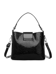 Detailed view of black crocodile pattern bucket bag with shiny silver metal D-ring hardware
