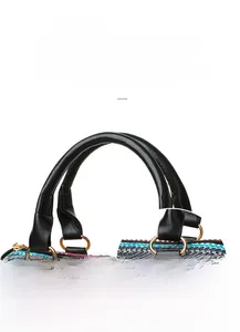 Close-up of reinforced handles and gold metal rings on a woven straw beach bag