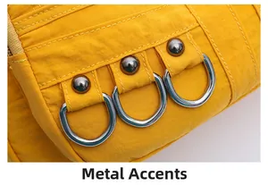 Detailed close-up of yellow fabric handbag with silver hardware D-rings and stitching