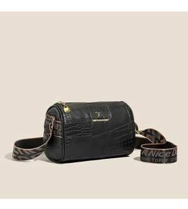 Detail of black crocodile texture mini bag with golden kangaroo logo and jacquard strap