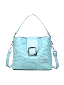Detail of light blue crocodile texture bucket bag with metal buckle and shoulder strap