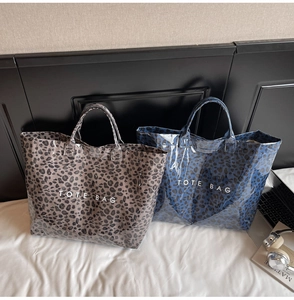 Detail of glossy leopard print tote bags in grey and blue with waterproof PVC coating