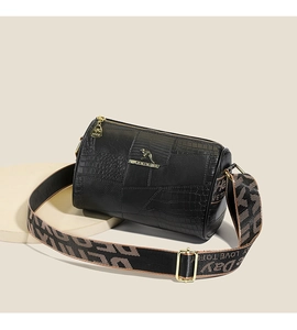 Detail of black cylinder bag showing faux crocodile texture and gold kangaroo logo