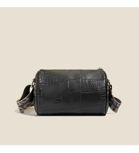Detail of mixed-texture pillow bag with crocodile pattern and jacquard strap
