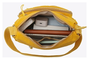 Top view of bright yellow crossbody bag showing multi-pocket interior storage capacity