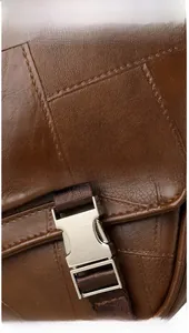 Detail of brown faux leather texture with silver metal buckle and nylon strap