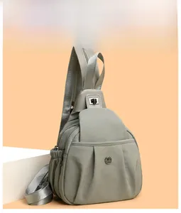 Detail of grey multi-functional nylon crossbody bag with metal twist lock and side pocket