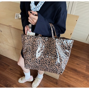 Detail of large leopard print tote bag with glossy finish and Tote Bag text on front