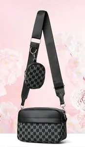 Detail der schwarzen Kuriertasche mit M-Buchstaben-Jacquard und kleinem Rundbeutel