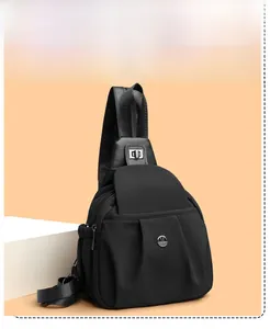 Detail of black nylon crossbody bag with pleated design and metallic M logo emblem