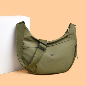 Olive green nylon half-moon crossbody bag with adjustable wide strap and metal logo