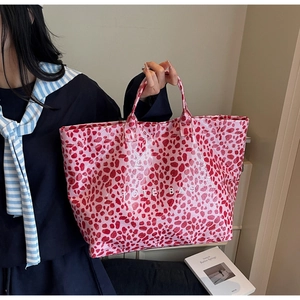 Detail view of pink leopard print tote bag with large capacity and white logo lettering