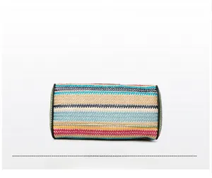 Detail of colorful woven cylinder bag bottom with black leather trim for beach style