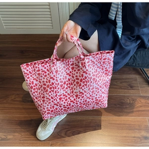 Detail of large leopard print tote bag with pink pattern and white TOTE BAG text