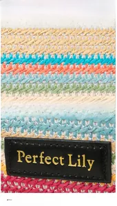 Detail showing the colorful woven straw texture and leather logo patch on the bucket bag