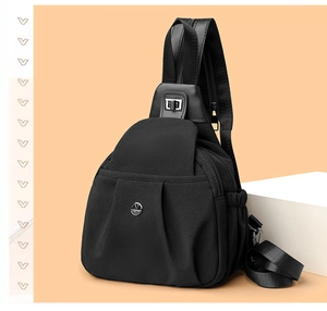 Macro view of water-resistant black crossbody bag with silver M logo and zipper