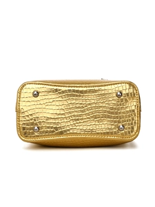 Detail view of metallic gold bucket bag bottom with protective metal rivets and croc texture