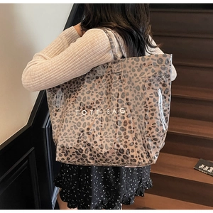 Detail of waterproof PVC tote bag with leopard print interior and white TOTE BAG text