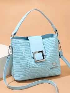 Close-up of light blue crocodile texture bucket bag with silver square buckle