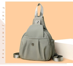 Macro view of gray lightweight nylon chest bag with multi-pocket design and metal logo