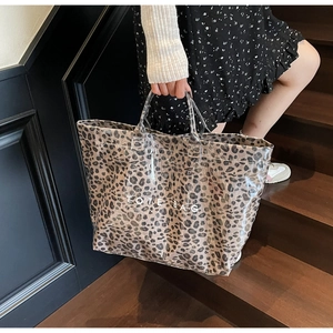 Detail of transparent PVC leopard print tote bag with white TOTE BAG text print