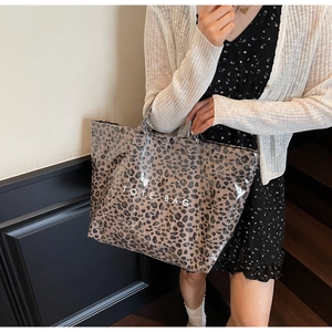 Detailed view of fashionable leopard print tote bag with white TOTE BAG text embroidery