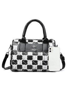 Detail of checkered canvas tote bag with leather handle and branded logo pocket