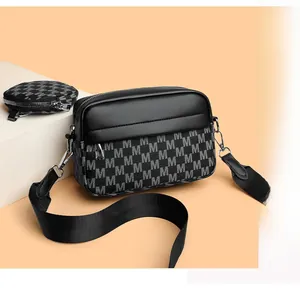 Detail der schwarzen Kuriertasche mit M-Muster und abnehmbarem Mini-Rund-Münzfach