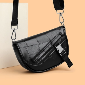 Women's black patchwork leather saddle bag with wide shoulder strap and metal buckle