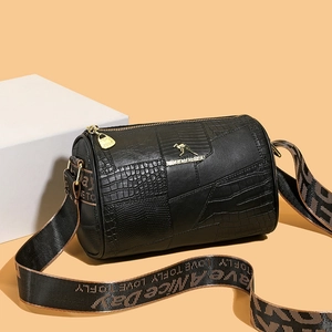 Black leather cylinder bag with exotic textures and stylish woven shoulder strap