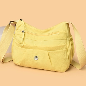 Lightweight yellow nylon crossbody bag with multi-zipper pockets and wide shoulder strap