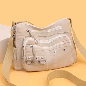 Beige nylon crossbody bag with multiple zip pockets and wide strap for casual commuting
