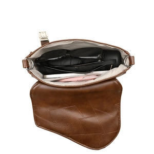 Brown retro patchwork saddle bag showing large capacity with phone and umbrella