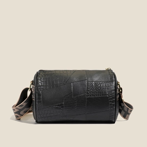 Minimalist black cylinder pillow bag with patchwork animal texture and wide strap