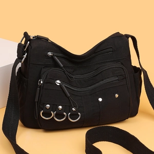 Black multi-pocket crossbody bag with metallic rings and adjustable fabric strap
