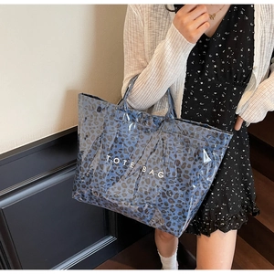 Blue leopard print tote bag with white TOTE BAG text shown in lifestyle indoor setting